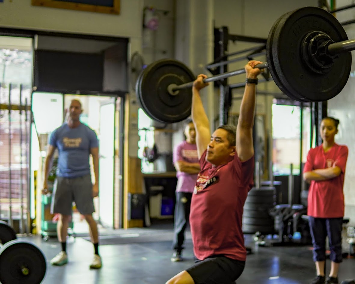Athlete locking out a barbell overhead