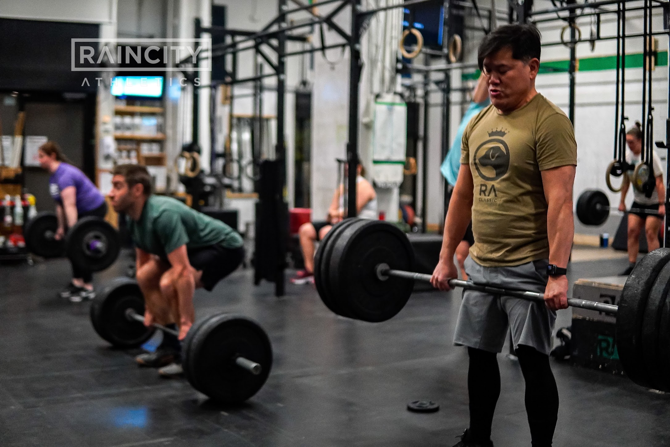 Athletes lined up under the barbell for back squats