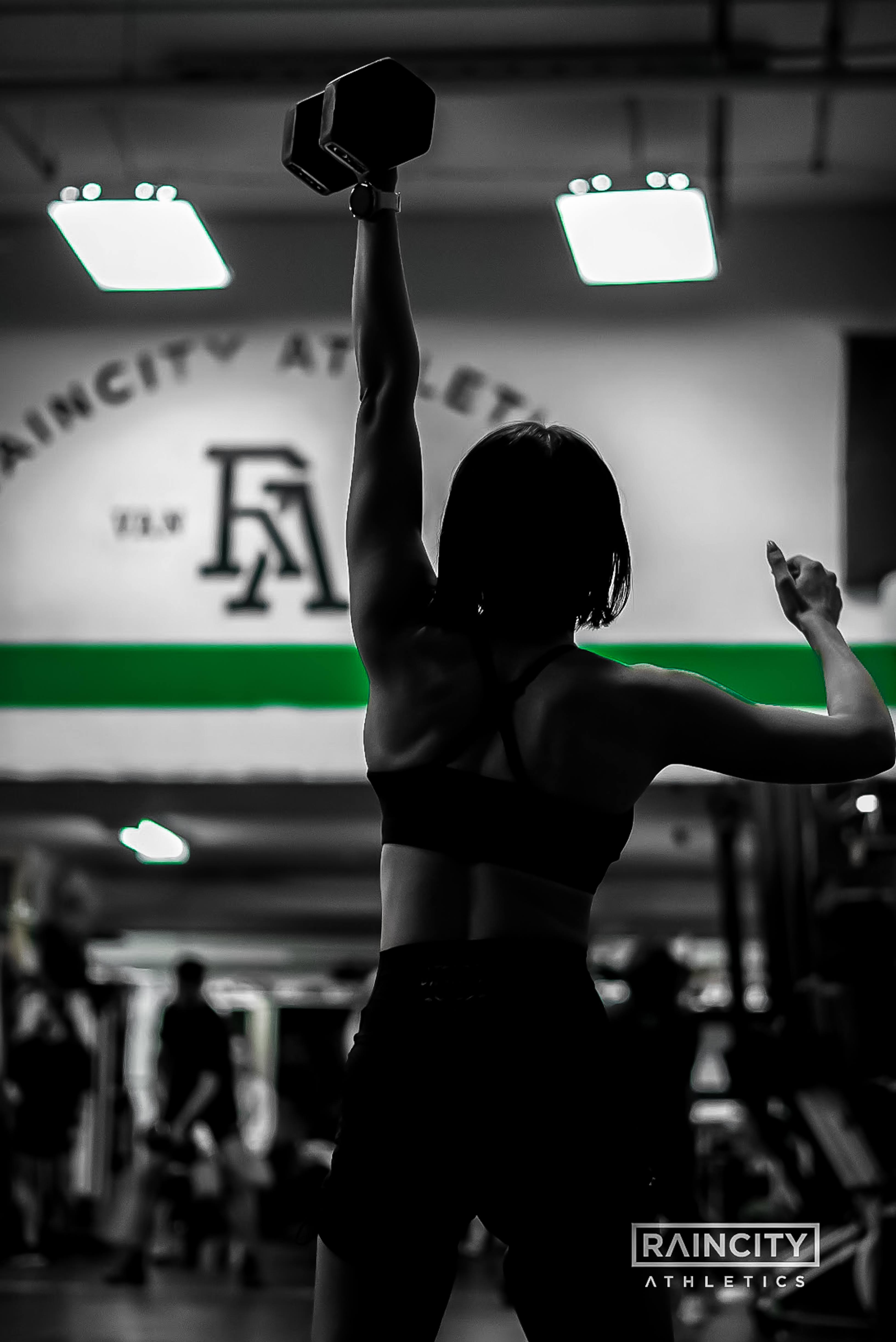 An athlete locking out a dumbbell snatch