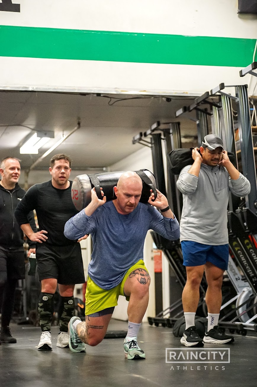 An athlete pushing a weighted sled during a HYROX session