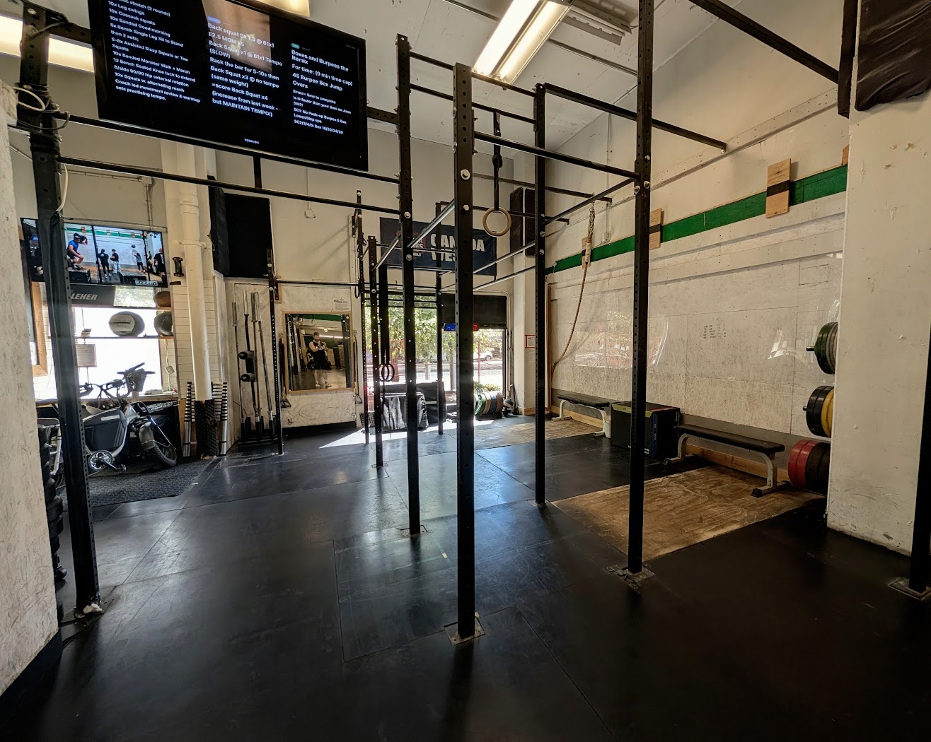 The Annex open-gym corner — three squat racks and two lifting platforms by the front window